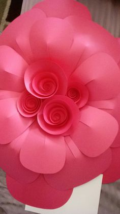 a large pink paper flower sitting on top of a white box