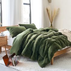 a bed with green blankets and pillows in a bedroom