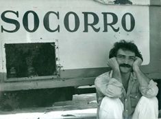 a man sitting in front of a truck with his hands to his face and the words soccorro on it