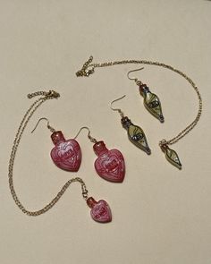 This set of jewelry is perfect for the Wizard World fans to add a unique look and elevate any outfit. Super lightweight with stainless steel components. Please note that this earrings are made by hand and there may be some detail variations. Dimensions are: -Love Potion Earrings: 6cm x 2.6cm -Liquid Luck Earrings: 6cm x 1.4cm -Love Potion and Liquid Luck Necklace: 16 inches adjustable.  You can go to the shop's instagram @iunobypaola to see videos and photos of these earrings and more. Glass Drop Earrings For Gift, Glass Jewelry For Valentine's Day Gift, Symbolic Drop Earrings Jewelry Gift, Symbolic Drop Earrings Jewelry As Gift, Symbolic Drop Earrings As A Gift, Valentine's Day Glass Jewelry Gift, Symbolic Teardrop Jewelry Gift, Symbolic Teardrop Jewelry For Gifts, Potion Earrings