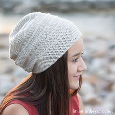 a girl with long hair wearing a white knitted hat and looking off into the distance