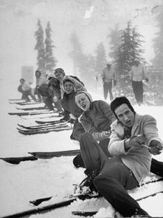 a group of people sitting on top of snow covered ground