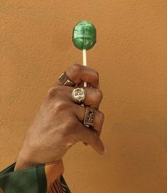 a person holding a green lollipop in their hand