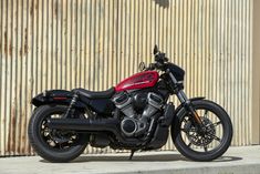 a red and black motorcycle parked in front of a building