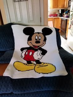 a crocheted mickey mouse pillow on a couch