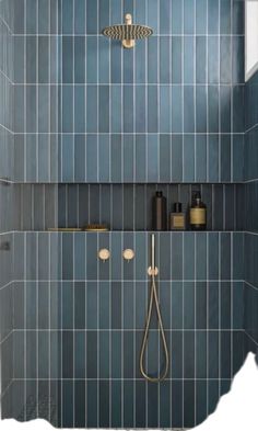 a bathroom with blue tile and gold fixtures on the shower head is shown in this image