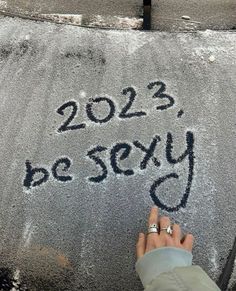 someone's hand writing on the pavement that says 2012, be sely and