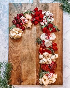 a wooden cutting board topped with fruit and veggies