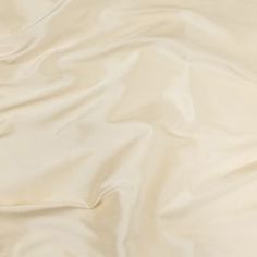 an unmade bed with white sheets and pillows