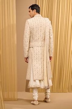 Ivory sherwani, hand embroidered using gold zari and threadwork, accentuated with sequins and French knots. Comes with an embroidered stole, kamarbandh and kurta. Paired with a churidar, safa and jutti fabric. - Aza Fashions Beige Chikankari Embroidered Sherwani For Reception, Beige Sherwani With Chikankari Embroidery For Reception, Beige Sherwani With Dupatta Traditional Drape, Ceremonial Cream Sherwani With Dupatta, Designer Traditional Wear In Cream With Intricate Embroidery, Designer Cream Traditional Wear With Chikankari Embroidery, Designer Cream Traditional Wear With Intricate Embroidery, Designer Cream Traditional Wear With Resham Embroidery, Designer Cream Traditional Wear With Drape