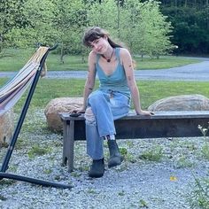 a woman sitting on a bench next to a hammock