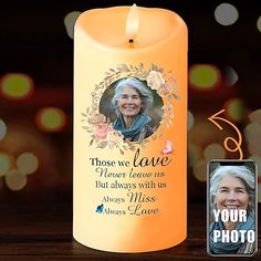 an orange candle with a photo on it next to a card that says, those we love