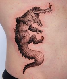 an alligator tattoo on the side of a woman's stomach