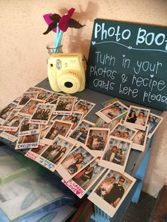 a table topped with lots of photos and a camera next to a sign that says photo booth