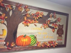 a bulletin board with fall leaves, pumpkins and an owl sitting on the tree