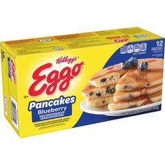 eggo pancakes with blueberries are on a white plate and in a yellow box