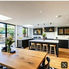 a kitchen with black cabinets and wooden floors