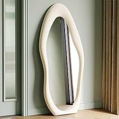 a white sculpture sitting on top of a wooden floor next to a door and window