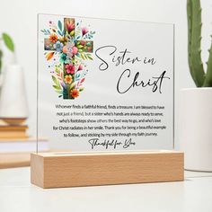 a wooden stand with a glass plaque on it that says sister in christ and flowers