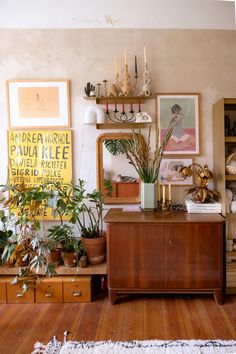 a living room filled with lots of furniture and plants on top of wooden shelves next to each other