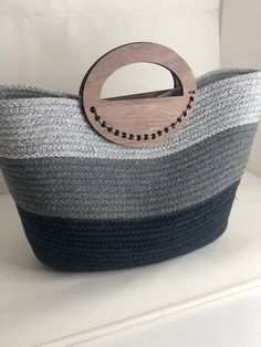 a gray and black basket with a wooden handle