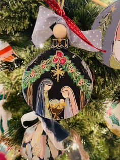 an ornament hanging from a christmas tree decorated with angels and snowflakes