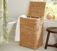 a basket sitting next to a window in a bathroom