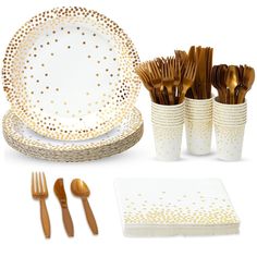 a table setting with gold polka dot plates, silverware and napkins