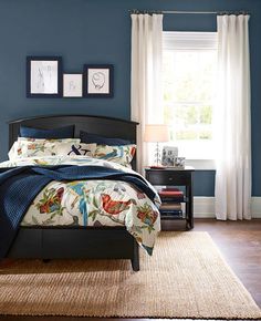 a bed room with a neatly made bed and blue walls