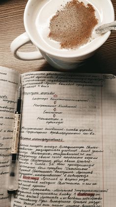 a cup of coffee sitting on top of an open book