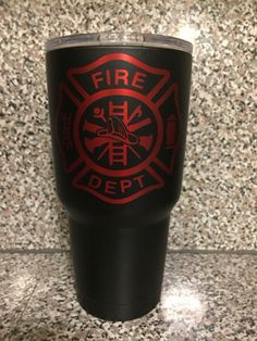 a fire department logo on a black tumbler cup sitting on a granite countertop