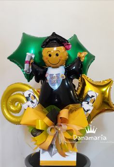 a glass vase with some balloons in it and a teddy bear holding a cell phone