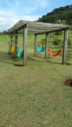 an outdoor area with hammocks, fire pit and picnic table in the background