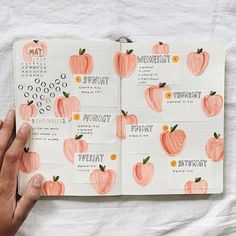 a hand is holding an open planner with peaches on it and the pages are lined up