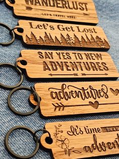 wooden keychains with words on them that read, let's get lost, say yes to new adventures and it's time for adventure