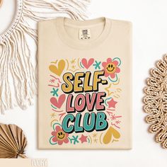 Embrace positivity with our Self Love Club T Shirt. This inspirational graphic tee promotes self-care and positive affirmation. Perfect for those who value self-love and want to spread positivity. The retro style design makes it a unique addition to your wardrobe. Whether you're treating yourself or looking for a thoughtful gift, this cute self-care top is an excellent choice. Get yours now and join the Self Love Club! 🌎 Comfort Colors 1717 Shirt | Timeless Style & Comfort Discover the essence of classic comfort with our Comfort Colors 1717 Unisex Garment-Dyed Heavyweight T-Shirt. A perfect blend of traditional style, modern durability, and eco-friendly craftsmanship. 🧵 Material & Quality: Made from 100% ring-spun cotton, this 6.1 oz/yd² (206.8 g/m²) shirt is pre-shrunk and garment-dyed Cute Self Care, Inspirational Graphic Tees, Self Love Club, Boho Shirt, Club T Shirt, Spread Positivity, Boho Shirts, Conscious Fashion, Love Club