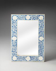 a blue and white mirror sitting on top of a table