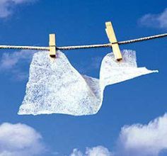 two pieces of white cloth hanging from a clothes line on a blue sky with clouds