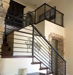 a stair case in a home with stone and steel railings on each handrail