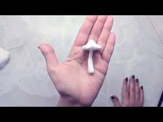 a hand holding a small white object in it's palm