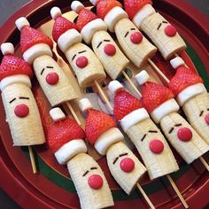 some strawberries and bananas are arranged on sticks with faces made to look like people