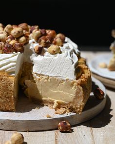 there is a cake that has been cut and served on a plate with nuts around it