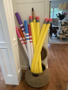 there are many different colored pencils in the basket next to the door and on the floor