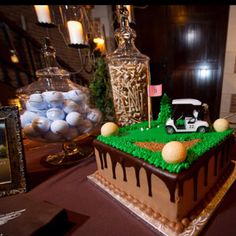 a golf themed cake is on display in front of two framed photos and some candles