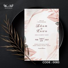 an elegant wedding card with watercolor flowers and leaves is on a black plate next to a