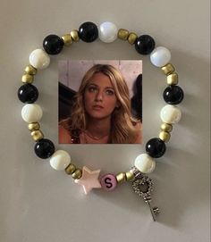 a bracelet with a star charm and a photo on the bead is attached to a wall