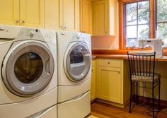 a washer and dryer sitting in a kitchen next to a table with chairs