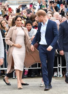 prince harry and his wife, the duke of cambridge, are walking together in front of a crowd