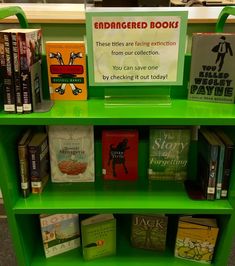 a green book shelf filled with lots of books next to a sign that says, enhanced books