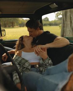 a man and woman kissing in the back of a pick up truck